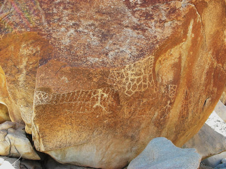 A busy boulder with shapes and human figures in Baja